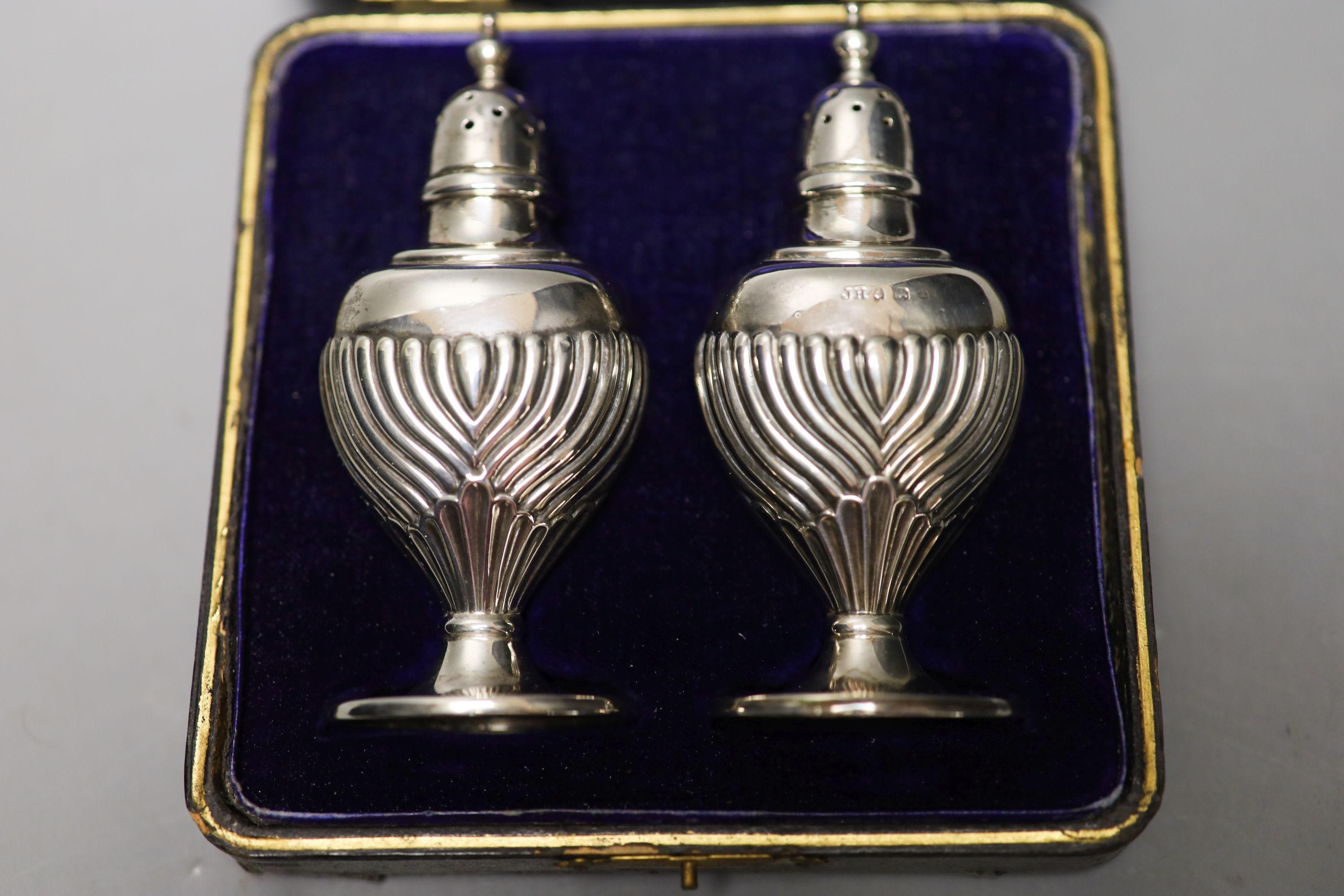 Four pairs of silver napkin rings including cased Victorian and a cased pair of silver pepperettes.